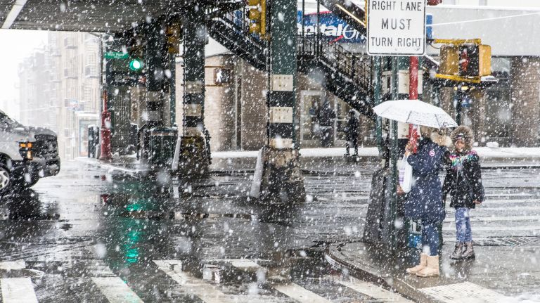 Pedestrians make their way through the snow on East 233rd Street and White Plains Road in the Bronx on April 2, 2018.