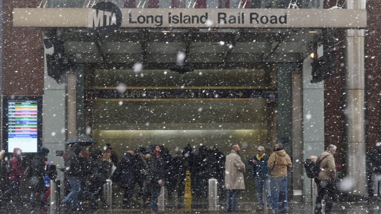 Snow falls outside he 34th Street entrance to the Long Island Rail Road at Penn Station in Manhattan on March 21, 2018.