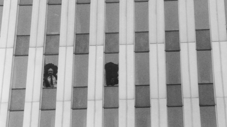 An office worker stands at a broken window of the smoke-filled World Trade Center after the explosion in the north tower on Feb. 26, 1993.