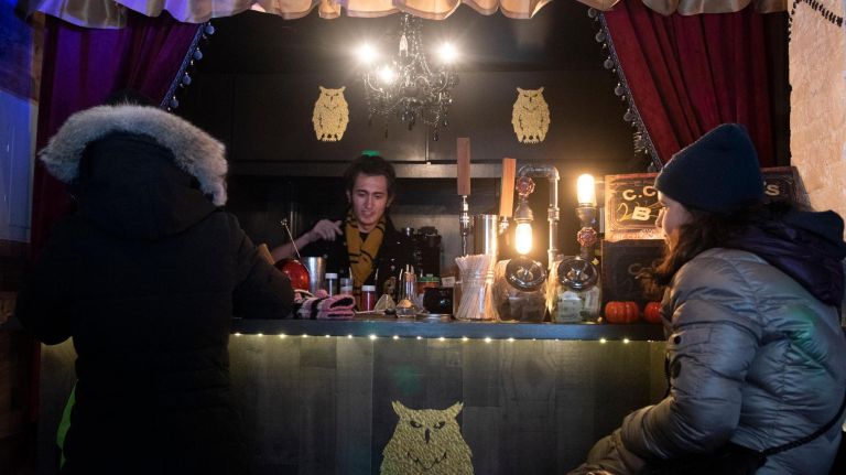 The staff at Steamy Hallows stays in theme to&nbsp;create drinks. Wearing all black, they create "potions" for the witches at the bar.