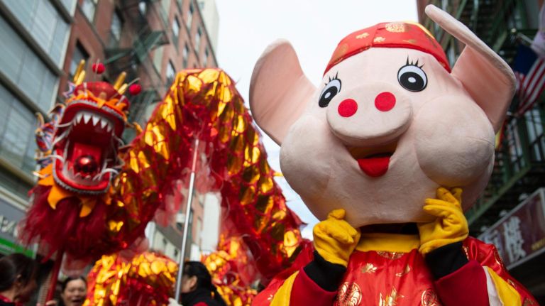 A person wearing a pig head (for the year of the pig) marches in the parade.