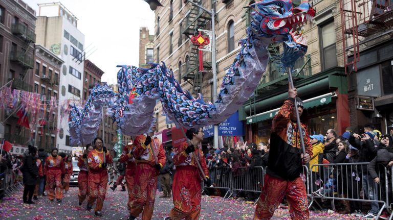 Dancers walking their dragon down the street.
