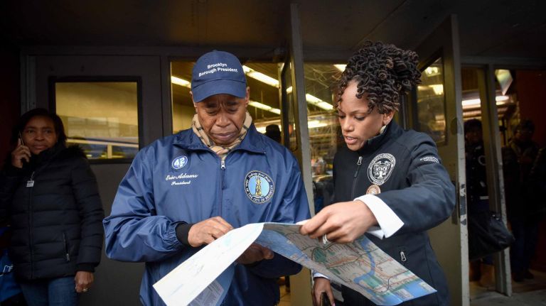 Borough President Eric Adams and community organizer Monique Waterman look at a map of the subway system&nbsp;outside the Church Avenue subway on Monday, several days after Ann Marie Washington was attacked.