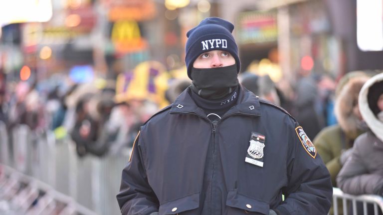 An officer is bundled up as New Year's Eve revelers get ready to celebrate in a frigid Times Square on Sunday, Dec. 31, 2017.