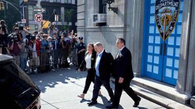 Former film mogul Harvey Weinstein walks in handcuffs from the NYPD