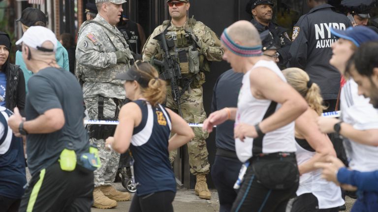 New York Army National Guard soldiers, including Capt. Michael Sicinski, center, of the 1st Battalion, 69th Infantry Regiment, keeps watch as runners turn onto Vernon Boulevard in Queens during the 2017 TCS New York City Marathon on Sunday, Nov. 5, 2017.
