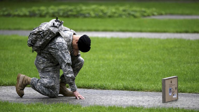 Army Reserve Sgt. Edwin Morales takes a knee for his cousin, FDNY Firefighter Ruben Correa, who died during the Sept. 11 attacks, during a commemoration ceremony Tuesday at Ground Zero.