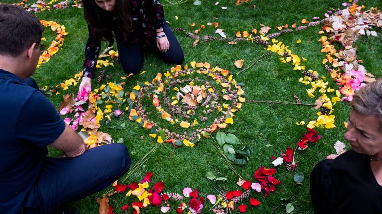 New Yorkers gather around an altar-like sculpture under the direction of artist Day Schildkret on Friday at the 9/11 Memorial.&nbsp;