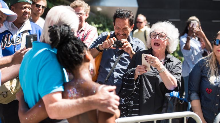 Christine Brady of Wappingers Falls, New York, takes a picture of her husband, Stephen Brady, with GoTopless Day parade participant Rouge, 28, of Brooklyn, in Manhattan on Saturday, Aug. 26, 2017.