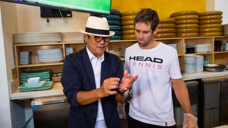 Chef Masahura Morimoto speaks to tennis player Bradley Klahn about sushi during the food tasting preview.