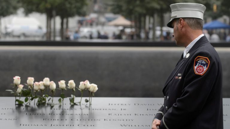 A firefighter stands at the edge of the 9/11 memorial's north pool during a commemoration ceremony marking the 17th anniversary of the terrorist attacks on Tuesday.