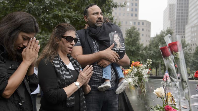 Families gather at the edge of the 9/11 memorial's north pool during a commemoration ceremony marking the 17th anniversary of the terrorist attacks on Tuesday.