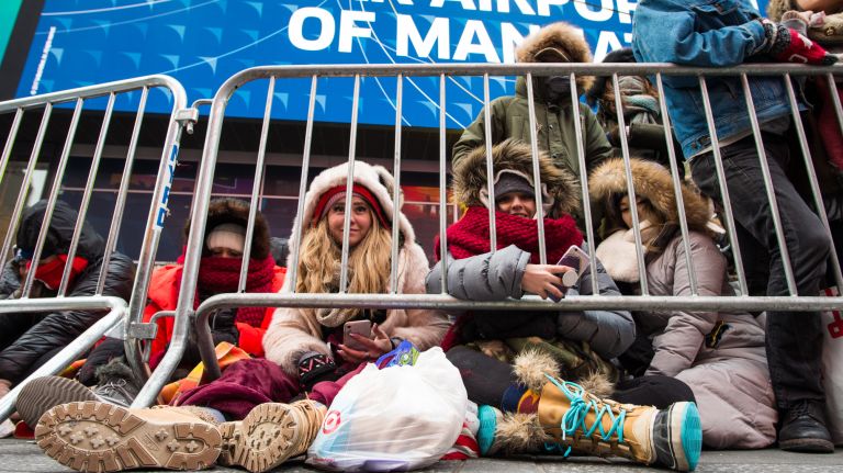 Dee Wilhite, 24, and Lindsay Savage, 20, both of Salt Lake City, hang out in Times Square before the New Year's Eve celebration on Sunday, Dec. 31, 2017.