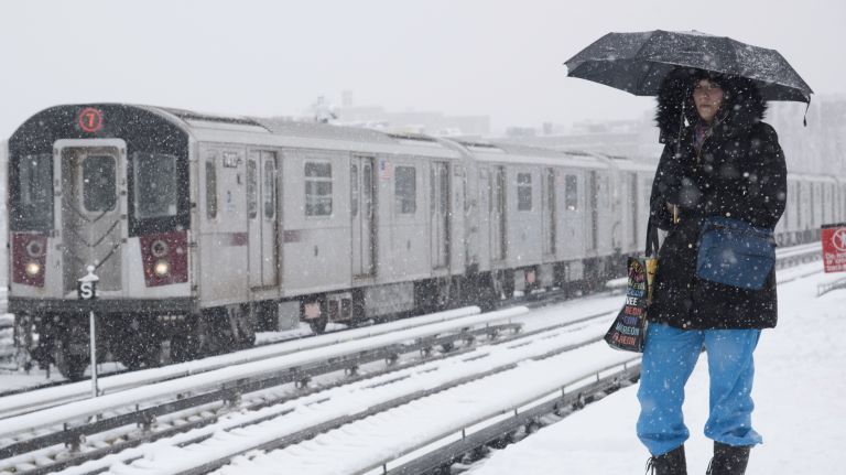 A woman waits for a Manhattan-bound 7 train at the 51st Street Station during the snow in Woodside, Queens, on April 2, 2018.