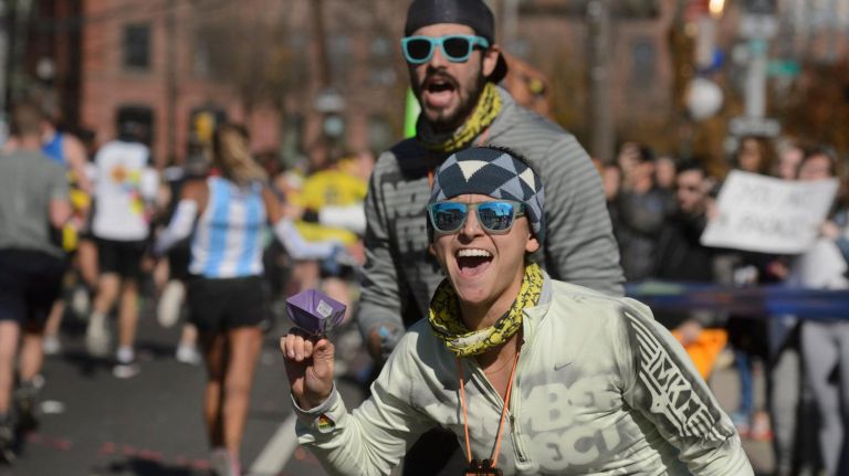 New Orleans resident Mia Fredericks and New York City resident Rob McCombs cheer as friend runs toward them.