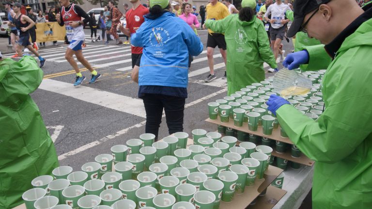 Volunteers hand out cups of Gatorade to runners on Vernon Boulevard in Queens during the 2017 TCS New York City Marathon on Sunday, Nov. 5, 2017.