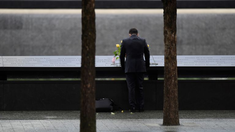 A person leaves flowers at the 9/11 memorial's north pool.