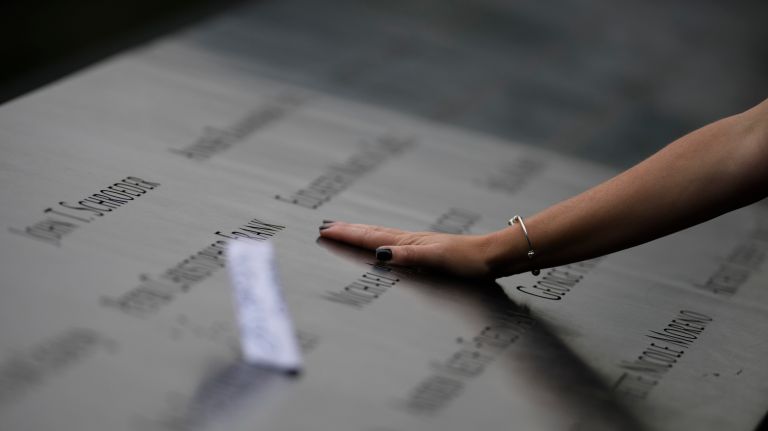 Families gather at the edge of the 9/11 memorial's north pool during a commemoration ceremony marking the 17th anniversary of the terrorist attacks on Tuesday.