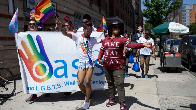 1 Bronx Pride March: Advocates parade through the streets 16 Yorlenni Sanchez, center left, of the Dominican Republic, dances with a woman selling shaved ice as members of the LGBTQ community walk along 161st Street during the Bronx Pride March.