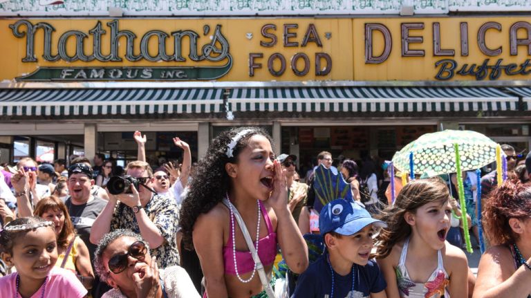 Kids watch participants from the sidelines at the Mermaid Parade.