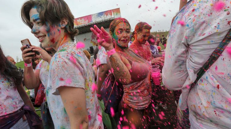 A reveler throws her gulal.