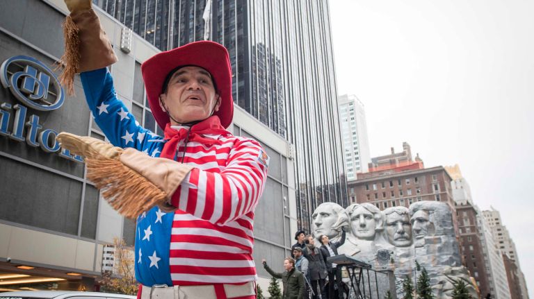 A street performer accompanies the Mount Rushmore float on Sixth Avenue near 59th Street on Thursday, November 24, 2016, during the 90th Macy's Thanksgiving Day Parade in Manhattan.
