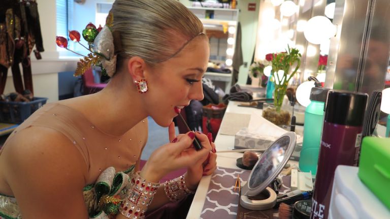 Shimko arrives with most of her makeup already done and will add an extra dab here and there before the show. It takes her about 10 minutes to intensify her makeup look with rosy blush, false lashes and a red lip so the stage lights don't 