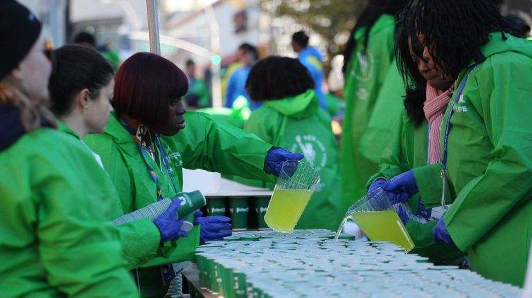 Volunteers pour Gatorade into cups to pass out to runners during the TCS New York City Marathon in New York City on Sunday, Nov. 6, 2016.