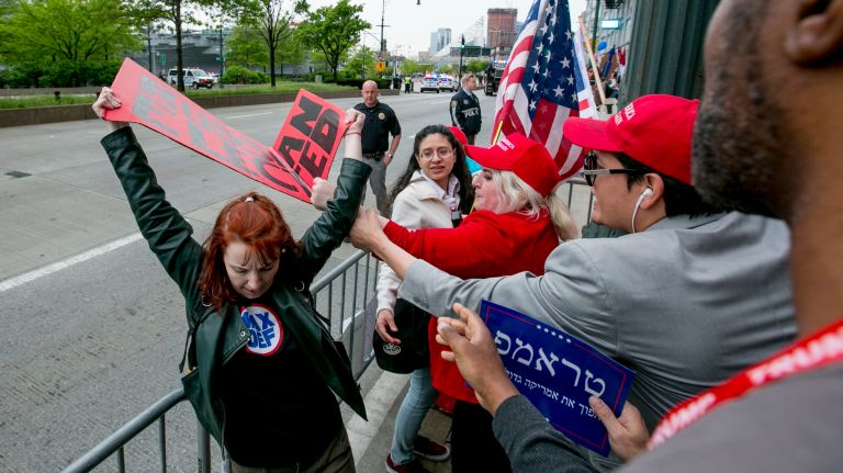 Pro-Trump protester Diane Atkinis of Brooklyn grabs the sign of an anti-Trump protester along the West Side Highway in Manhattan before the president's visit to the Intrepid Air and Space Museum, on May 4, 2017.