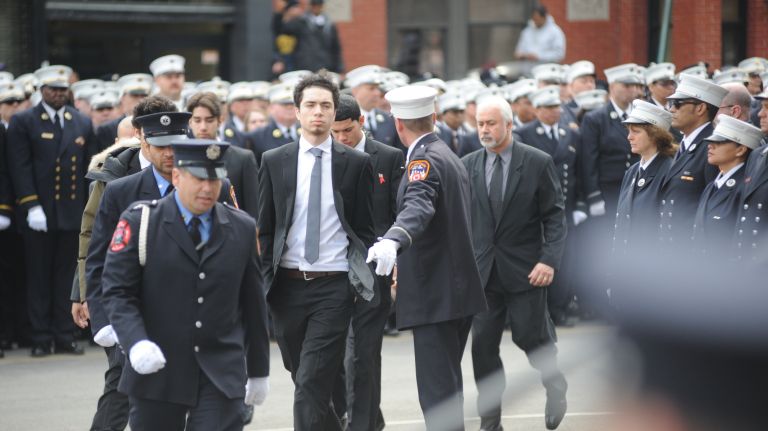The sons of FDNY EMT Yadira Arroyo as well as fire department members arrive Saturday, March 25, 2017, at St. Nicholas of Tolentine Roman Catholic Church on University Avenue in the Bronx for her funeral Mass.