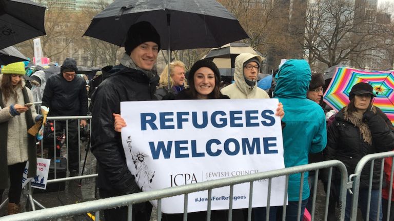 Protesters brave the rain as they gather in lower Manhattan's Battery Park to attend a rally in support of refugees on Feb. 12, 2017. 