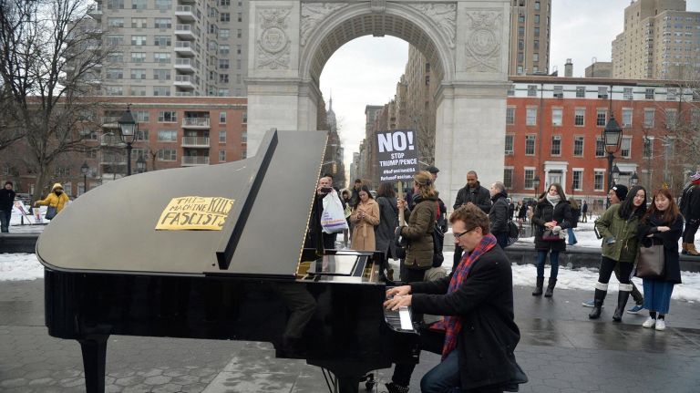 Manhattan resident Colin Huggins (39) performs on a piano at a Washington Square Park rally on Saturday, Feb. 11, 2017. The rally is being held to challenge the criminalization of immigrants under the NYPD's current Broken Windows policy, before it worsens under Trump's far-right administration.