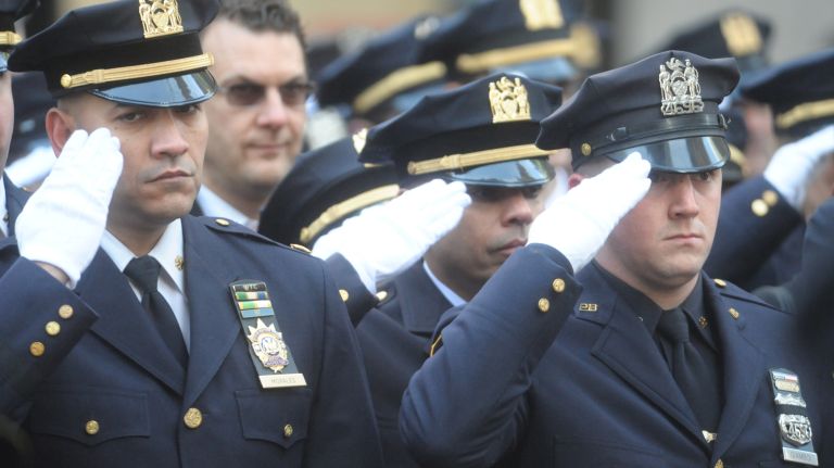 Police officers salute during the funeral mass for NYPD Det. Steven McDonald at St .Patricks Cathedral on Jan 13, 2017.