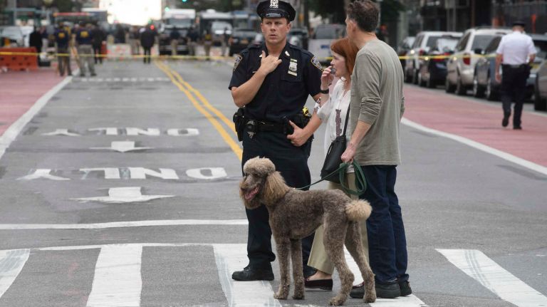 Chelsea explosion injures multiple people in Manhattan: See photos from the scene 13 A couple with a dog walk past the scene of an explosion in Chelsea on Sept. 18, 2016.