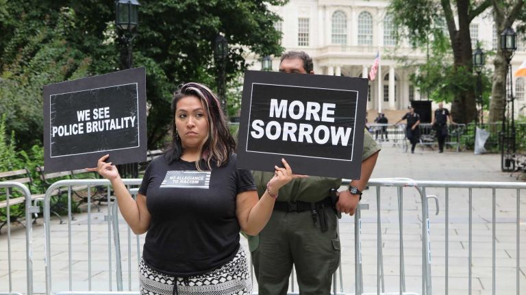 A woman held signs calling attention to police brutality in City Hall Park on Aug. 1, 2016.