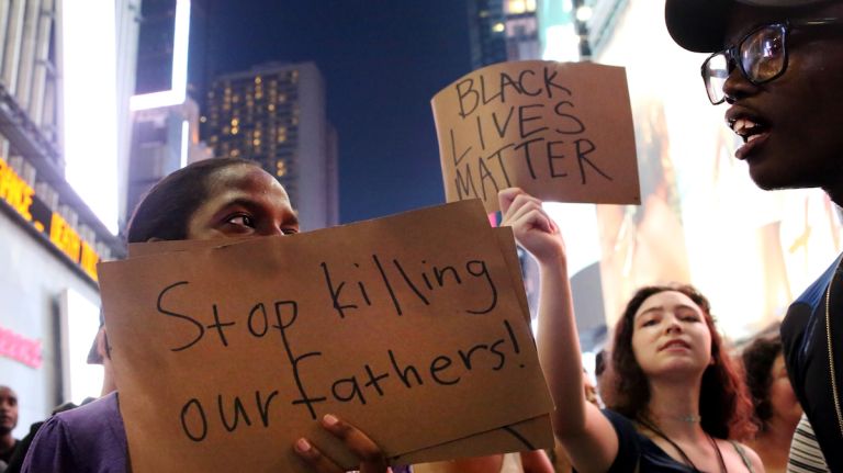 Demonstrators let their signs do the talking during a march through Manhattan on July 7, 2016, to protest the deaths of two black men at the hands of police in Louisiana and Minnesota. 