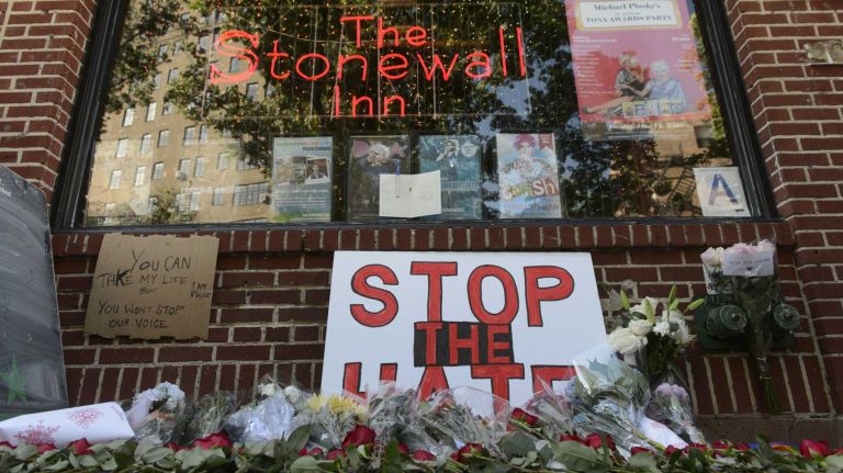 People leave flowers at The Stonewall Inn in Manhattan on Sunday, June 12, 2016, at a vigil for Orlando, Fla., shooting victims. A gunman armed with an assault rifle and handgun killed 49 people and wounded 53 at Pulse, a gay nightclub in Orlando, in what officials termed the worst mass shooting in U.S. history.