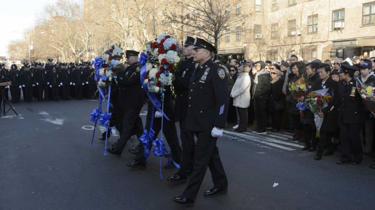 Members of the New York Police Department hold a prayer vigil and wreath-laying ceremony honoring Detective WenJian Liu and Detective Rafael Ramos on Tompkins Avenue in Brooklyn on Sunday, Dec. 20, 2015. Liu and Ramos were shot and while in a squad car on Tompkins Avenue last December.