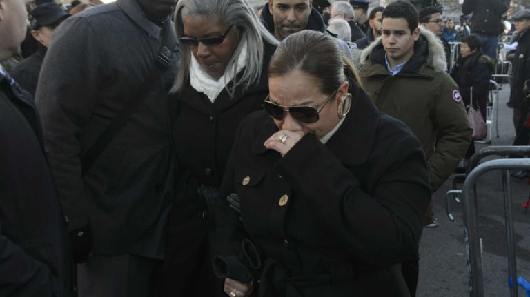Maritza Ramos, cries during a prayer vigil and wreath-laying ceremony honoring her husband Detective Rafael Ramos and Detective WenJian Liu on Tompkins Avenue in Brooklyn on Sunday, Dec. 20, 2015. Liu and Ramos were shot and while in a squad car on Tompkins Avenue last December.