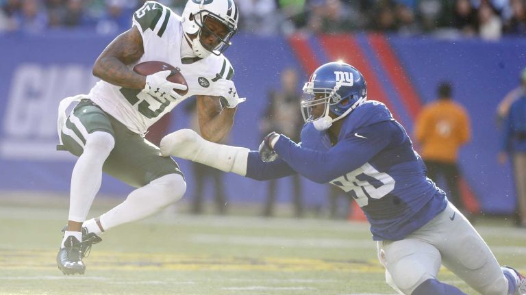 Brandon Marshall #15 of the New York Jets hauls in a reception against Jason Pierre-Paul #90 of the New York Giants at MetLife Stadium on Sunday, Dec. 6, 2015 in East Rutherford, N.J.
