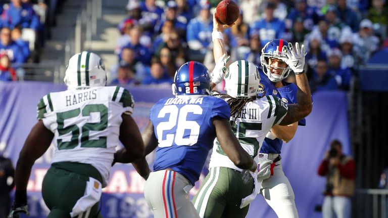 Eli Manning #10 of the New York Giants attempts a pass against Calvin Pryor #25 of the New York Jets to teammate Orleans Darkwa #26 at MetLife Stadium on Sunday, Dec. 6, 2015 in East Rutherford, N.J.