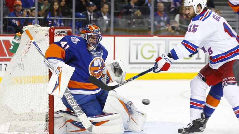 Jaroslav Halak #41 of the New York Islanders makes a second period save as Tanner Glass #15 of the New York Rangers tries for the tip at Barclays Center on Wednesday, Dec. 30, 2015 in Brooklyn, New York.