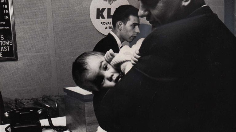 During the November 9, 1965 blackout, air traffic in and out of JFK Airport was suspended. Here, Homer Hartness of Dover, Delaware holds his one-year-old daughter Denise as he checks the status of a flight that was bringing his wife back from London.