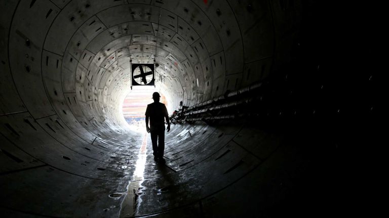New York, NY - Vince DeNina, Inspector on the East Side Access tunnel project, walks near the opening of Tunnel A in Queens, not far from where an adjacent tunnel, B/C lay, now extends to and just 6 feet under the LIRR main tracks in Long Island City where underground tunneling is complete. TBM machines have been tunneling below street level as part of the East Side Access project. MTA Chairman Joseph Lhota announced that the last drilling machine completed work on July 22 in tunnel B/C as part of the East Side Access project on the Queens side. A TBM drilling/tunneling machine named 