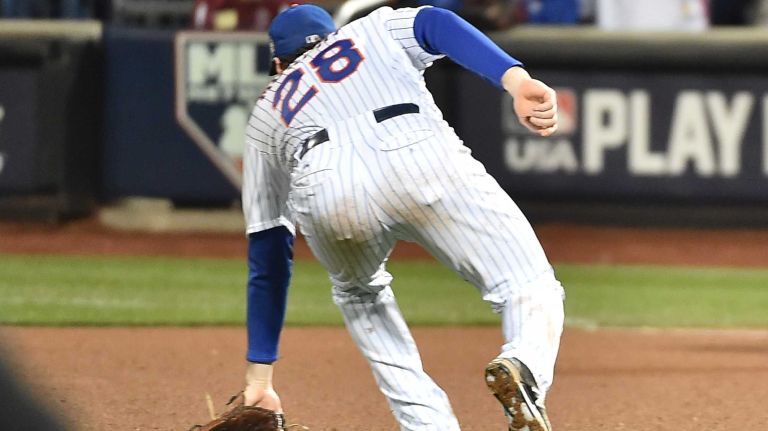 New York Mets second baseman Daniel Murphy makes an error on the ball hit by Kansas City Royals first baseman Eric Hosmer in the eighth inning during Game 4 of the World Series against the Kansas City Royals at Citi Field on Saturday, Oct. 31, 2015.