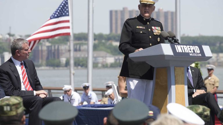New York City Mayor Bill de Blasio, left, listens as Gen. John F. Kelly, of the U.S. Marine Corps, the commander of the United States Southern Command, speaks during a Memorial Day Ceremony at the Intrepid Sea, Air and Space Museum Complex on Monday, May 25, 2015. Gen. Kelly's youngest son, 2nd Lieutenant Robert Michael Kelly, was killed in action in Sangin, Afghanistan, on Nov. 9, 2010.