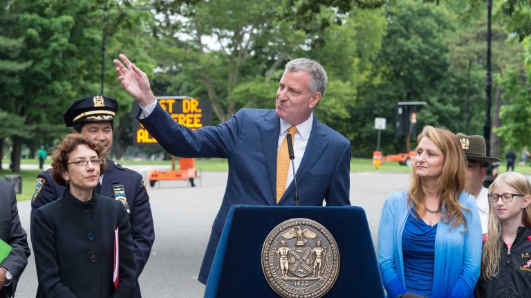 Mayor Bill de Blasio announced Thursday, June 18, 2015, that Central Park and Prospect Park will be mostly car free. The mayor made the announcement at the Bartel-Pritchard Square entrance to Prospect Park in Brooklyn. He is flanked by DOT Commissioner Polly Trottenberg, left, and Sue Donoghue, Prospect Park administrator and president of the Prospect Park Alliance.