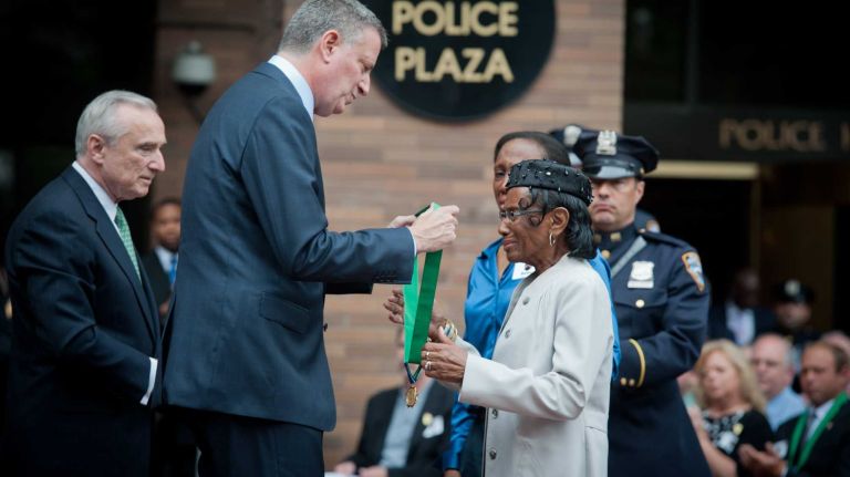 Vivian Barnes receives a Distinguished Service Medal on Tuesday, June 10, 2014 from Mayor Bill de Blasio and Police Commissioner William Bratton on behalf of her daughter, Police Officer Karen Barnes, who died of 9/11 related illness in 2011.