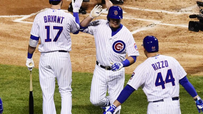 NLCS Game 3: Mets vs. Cubs 60 Chicago Cubs leftfielder Kyle Schwarber (12) is high-fived at home by Chicago Cubs third baseman Kris Bryant (17) and Chicago Cubs first baseman Anthony Rizzo (44) after a first-inning home run during Game 3 of the NLCS against the New York Mets at Wrigley Field on Tuesday, Oct. 20, 2015.