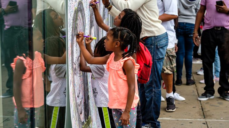 Young New Yorkers sign a mural for the late 